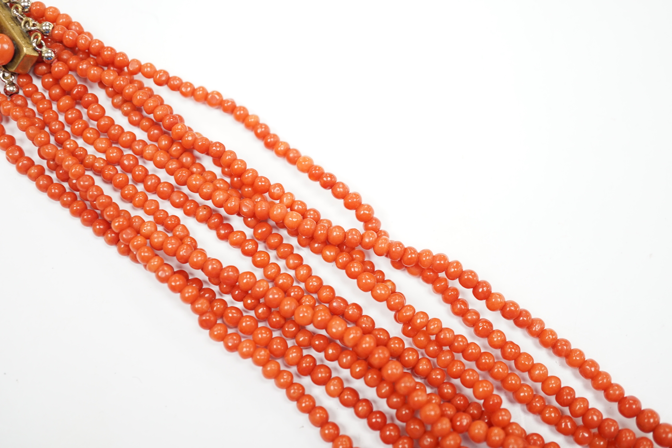 A five strand coral bead choker necklace, with coral set yellow metal clasp, approx. 44cm.